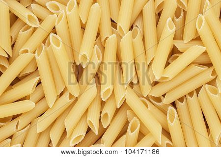 dry uncooked penne pasta texture background