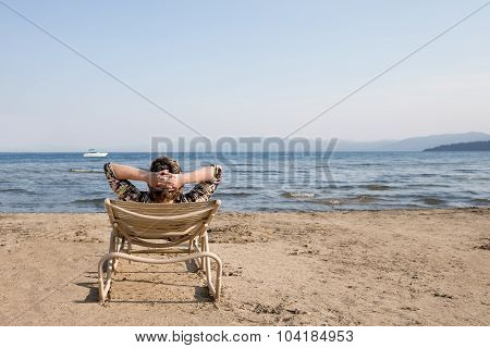 Woman In Beach Chair Looking Away At Horizon