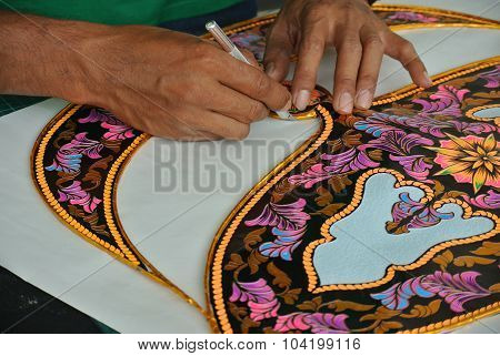 Malaysian kite maker working on a kite in his workshop