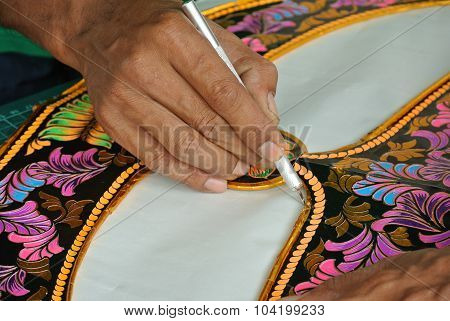 Malaysian kite maker working on a kite in his workshop