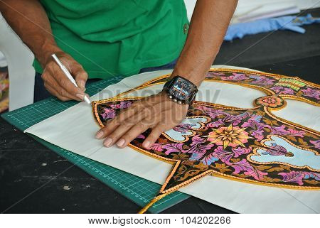 Malaysian kite maker working on a kite in his workshop