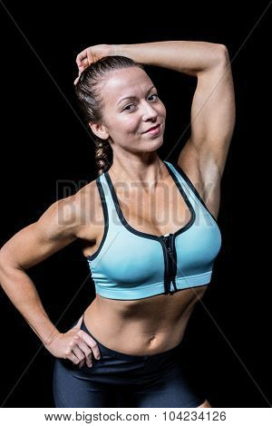 Portrait of fit smiling woman against black abckground