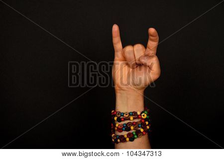 Hand With Devil Horns And Colorful Beads Isolated On Black