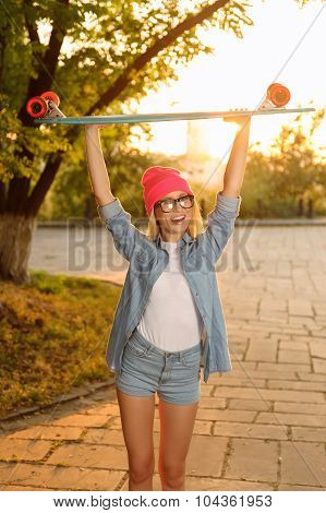 Overjoyed girl holding skateboard