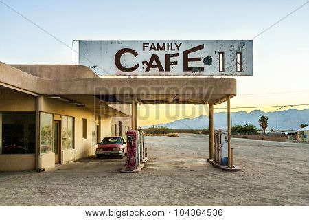 Wrecked Car At An Abandoned Petrol Station In The Desert Village Of Desert Center In Sunset