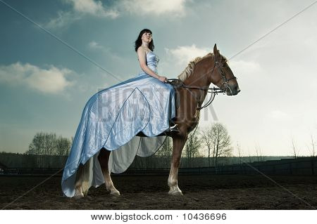 Hermosa mujer cabalgando sobre un caballo marrón