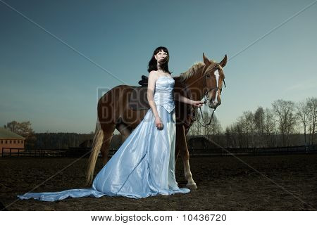 Hermosa joven con un caballo marrón