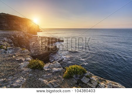Stunning Coastal Landscape With Long Exposure Waves Crashing At Sunrise