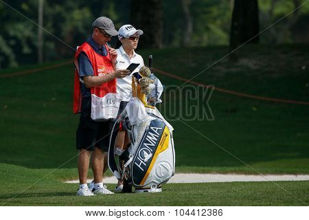 KUALA LUMPUR, MALAYSIA - OCTOBER 09, 2015: South Korea's Ryu So Yeon discusses with her caddy on the fairway of the KL Golf & Country Club at the 2015 Sime Darby LPGA Malaysia golf tournament.