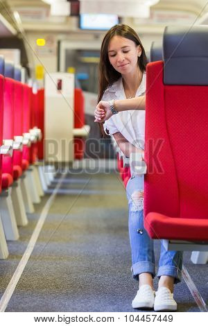 Young happy woman traveling by train