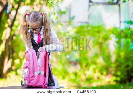 Happy little schoolgirl going back to school outdoor