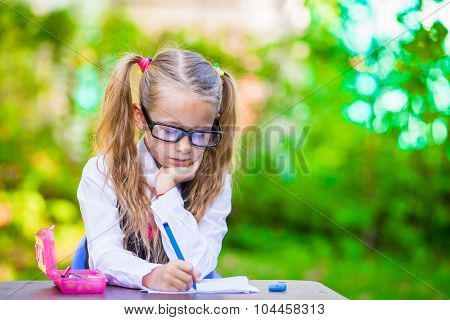 Little happy girl with pencils outdoors. Back to school.