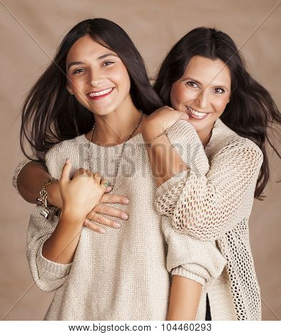 cute pretty teen daughter with mature mothr hugging, fashion style brunette