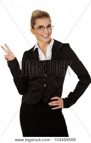 Happy businesswoman showing victory sign.
