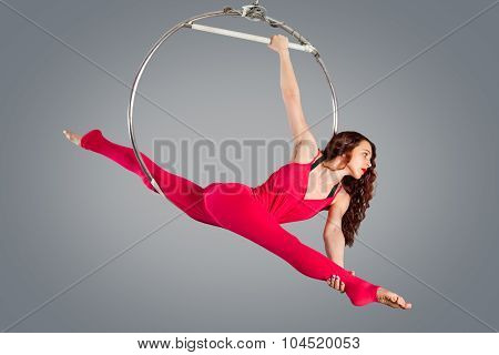 Plastic Beautiful Girl Gymnast On Acrobatic Circus Ring In Flesh-colored Suit. Aerial Ring.