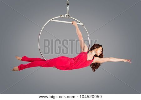 Plastic Beautiful Girl Gymnast On Acrobatic Circus Ring In Flesh-colored Suit. Aerial Ring.