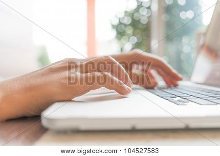 Closeup of business woman hand typing on laptop keyboard