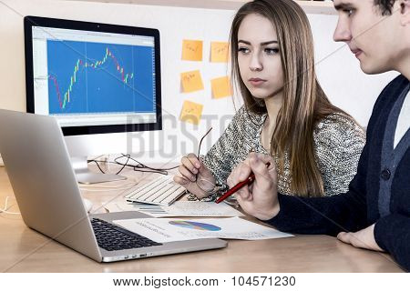 Young man and woman looking at computer screen