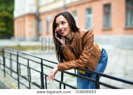 Portrait Of A Beautiful Young Woman Talking On The Phone In The Urban Landscape.