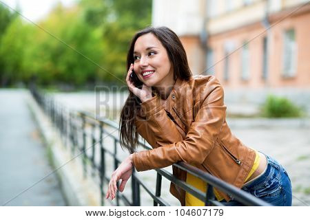 Portrait Of A Beautiful Young Woman Talking On The Phone In The Urban Landscape.