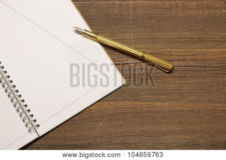 Notebook With Blank Page  And Golden Pen  On Wood Table