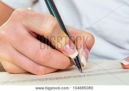 a woman signs a contract or a will with a fountain pen.