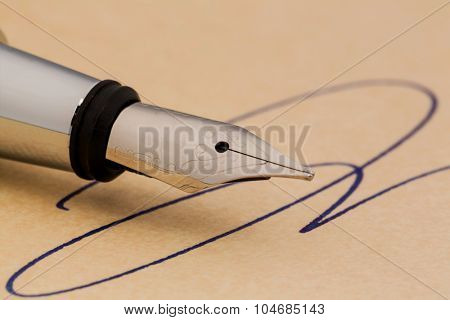 a signature and a fountain pen on yellow paper. symbolic photo for contract, testament and grafologie