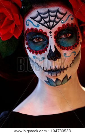 Closeup portrait of scary woman in santa muerte halloween makeup.