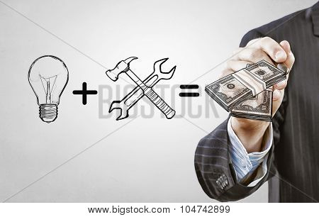 Close up of businessman drawing money making formula