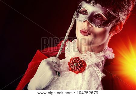 Handsome vampire wearing venetian mask. Halloween carnival. Dracula costume.