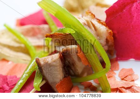 Closeup of a skewer of pork jowls.