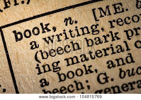 Close-up Of The Word Book And Its Definition On Old Textured Yellow Paper.