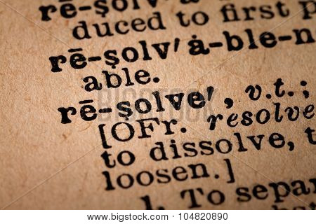 Close-up Of An Opened Dictionary Showing The Word Resolve