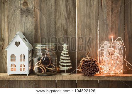 Sweet home. White Christmas decor on vintage natural wooden background. Cinnamon sticks and dried citrus. Cafe shelf.