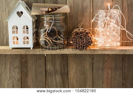 Sweet home. White Christmas decor on vintage natural wooden background. Cinnamon sticks and dried citrus. Cafe shelf. Space for custom text.