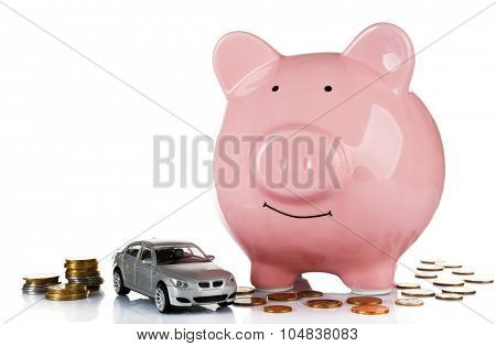 Piggy bank with car toy and coins around, isolated on white