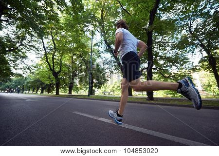 healthy athlete man jogging at morning on empty  roat in the city