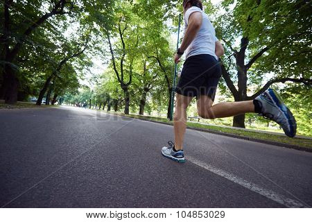 healthy athlete man jogging at morning on empty  roat in the city