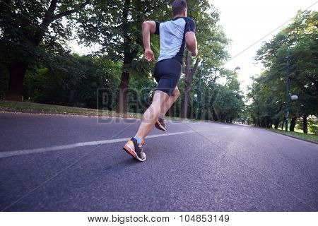 healthy athlete man jogging at morning on empty  roat in the city