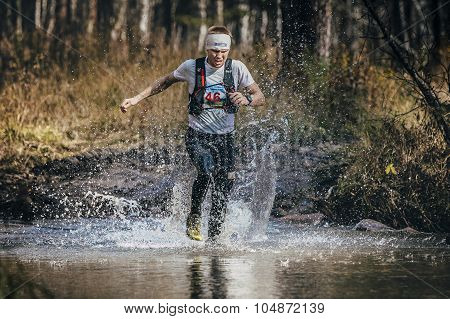 runner middle-aged man crossing a mountain river