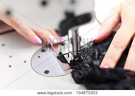Seamstress sewing on the sewing machine in the manufacturing plant