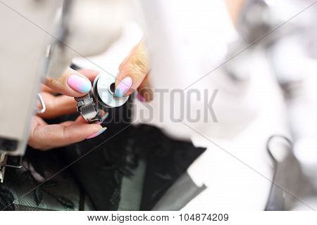 Sewing on a machine.