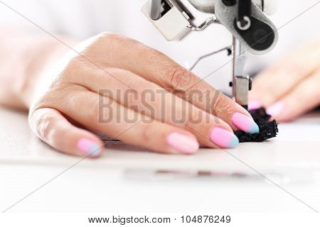 Seamstress sewing on the sewing machine in the manufacturing plant