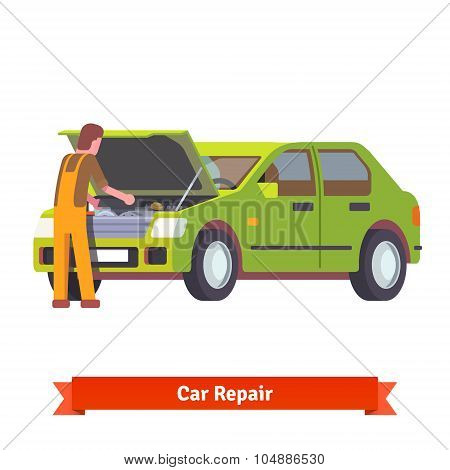 Car mechanic checking engine at car service