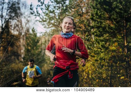 young smiling girl runner running in autumn Park