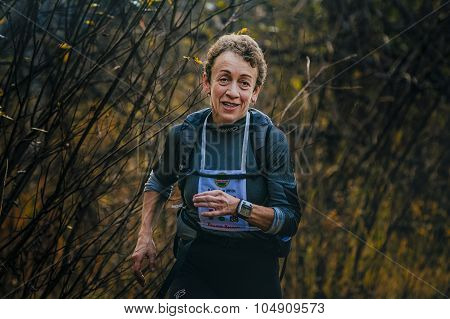 woman of senior years running through woods