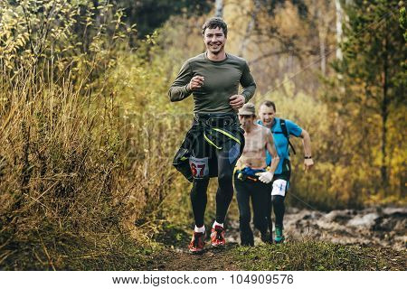 beautiful smiling man running in autumn forest