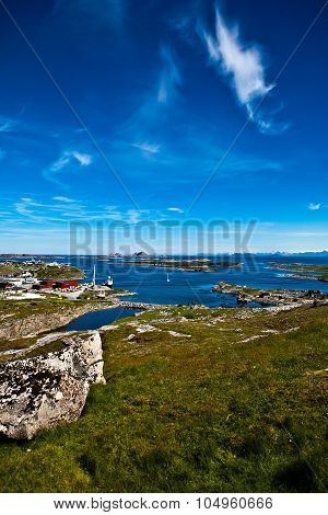 Norwegian summer scenery with sea green meadow and deep blue sky with some long shape clouds