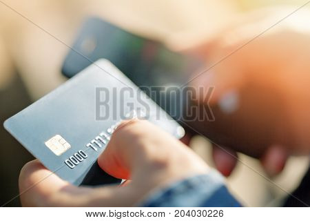 A man uses a mobile phone to pay for utilities. Concepts of using mobile technologies and smartphone in mobile applications in the online business for payment with a credit card remotely