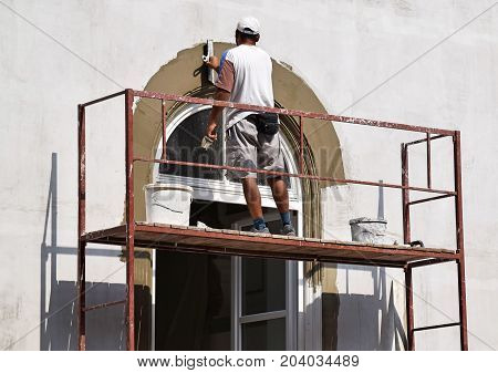 Construction worker works on the restoration of a building